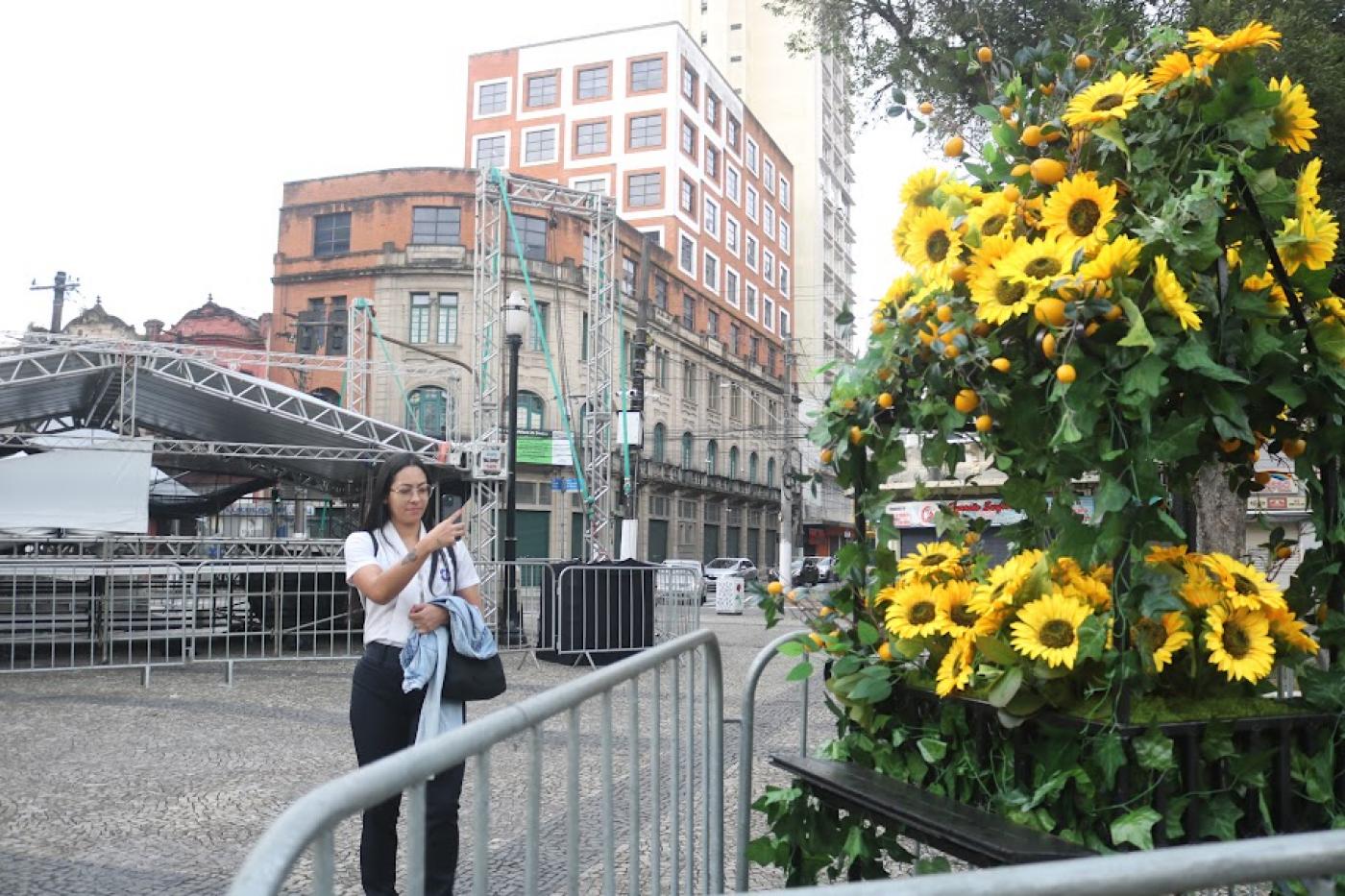 pessoa tirando foto de arranjo de flores #paratodosverem