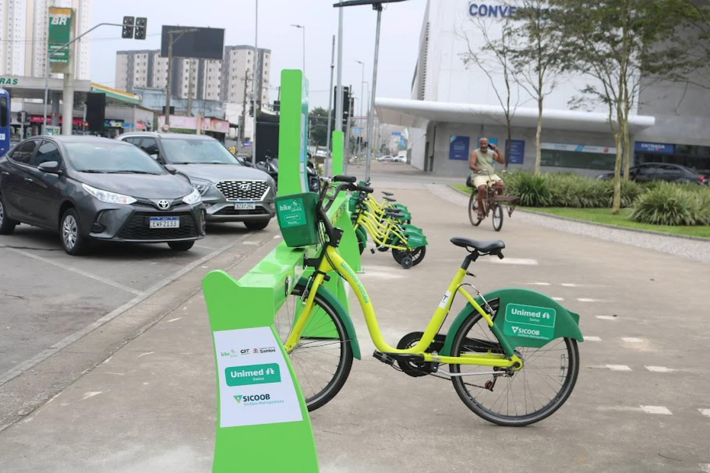 estação de bikes com bicicleta adulto em primeiro plano e kids atrás. #paratodosverem 