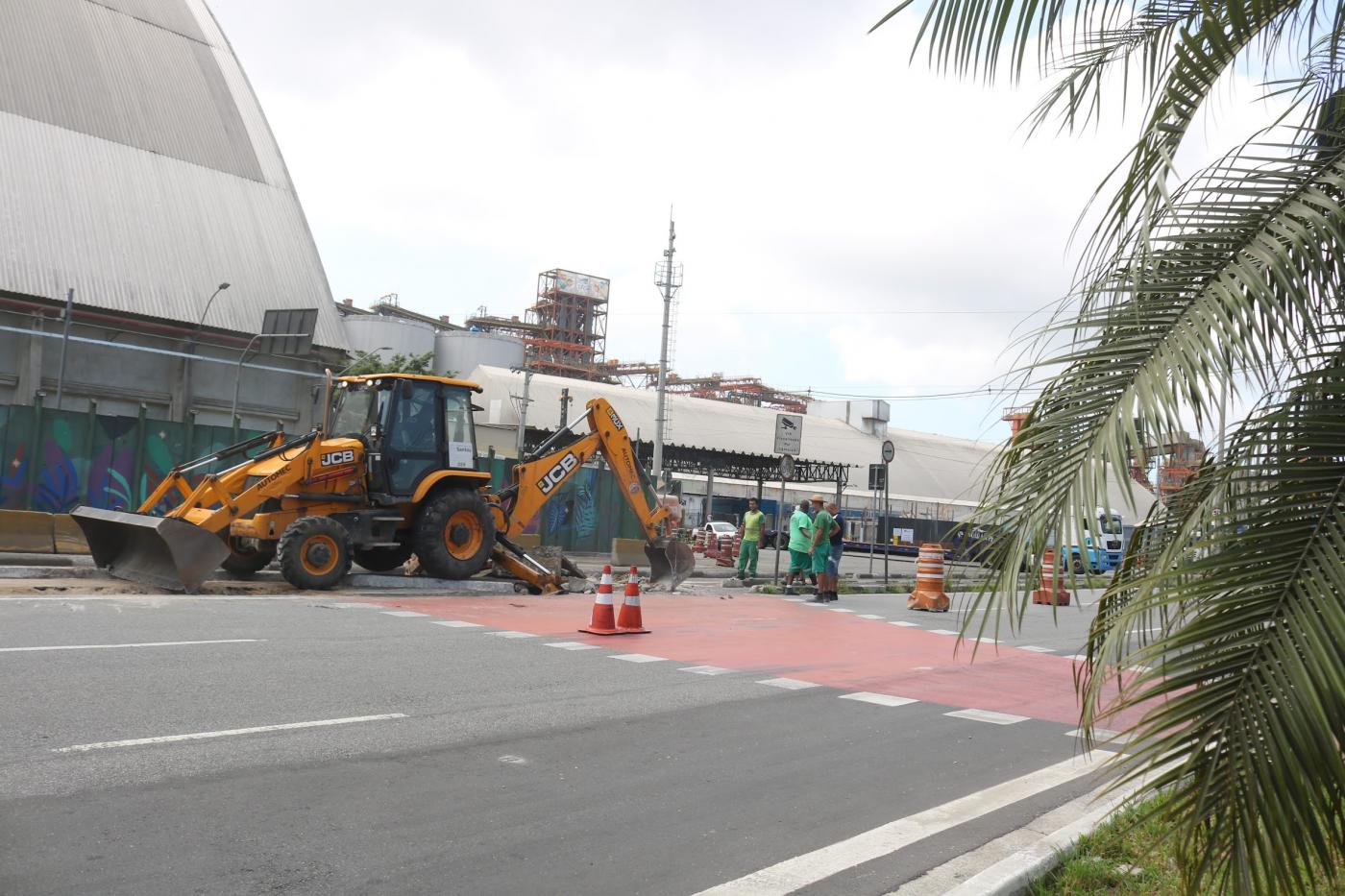 trator quebra e recolhe pedaços do asfalto em canteiro central de avenida. #paratodosverem 