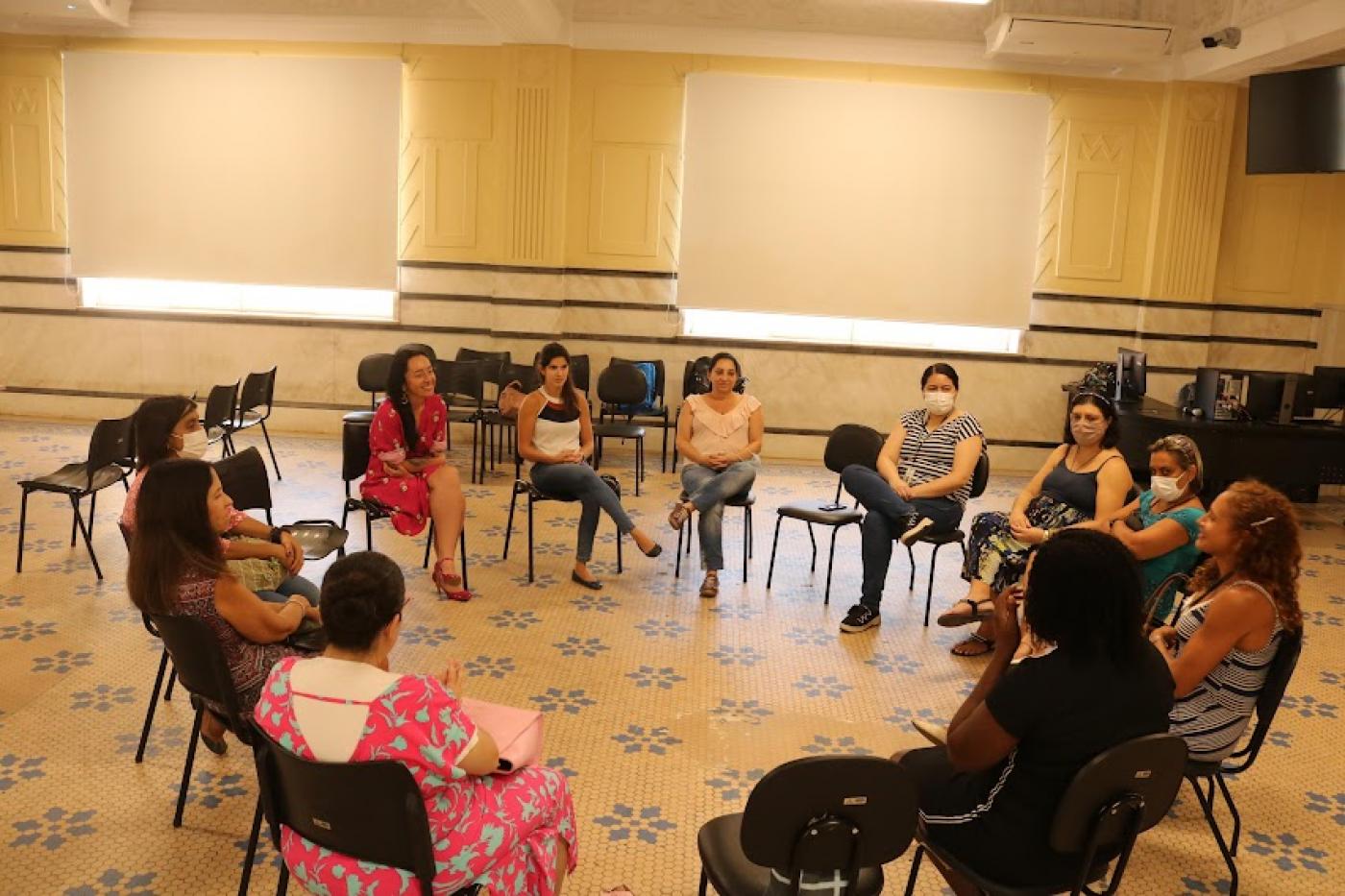 mulheres estão reunidas em roda conversando. #paratodosverem