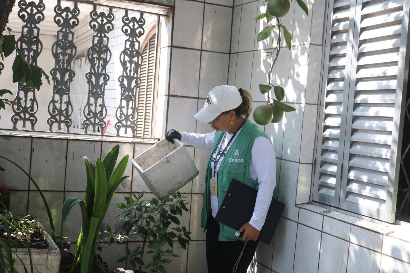 agente da dengue segura recipiente que acumula água. #paratodosverem