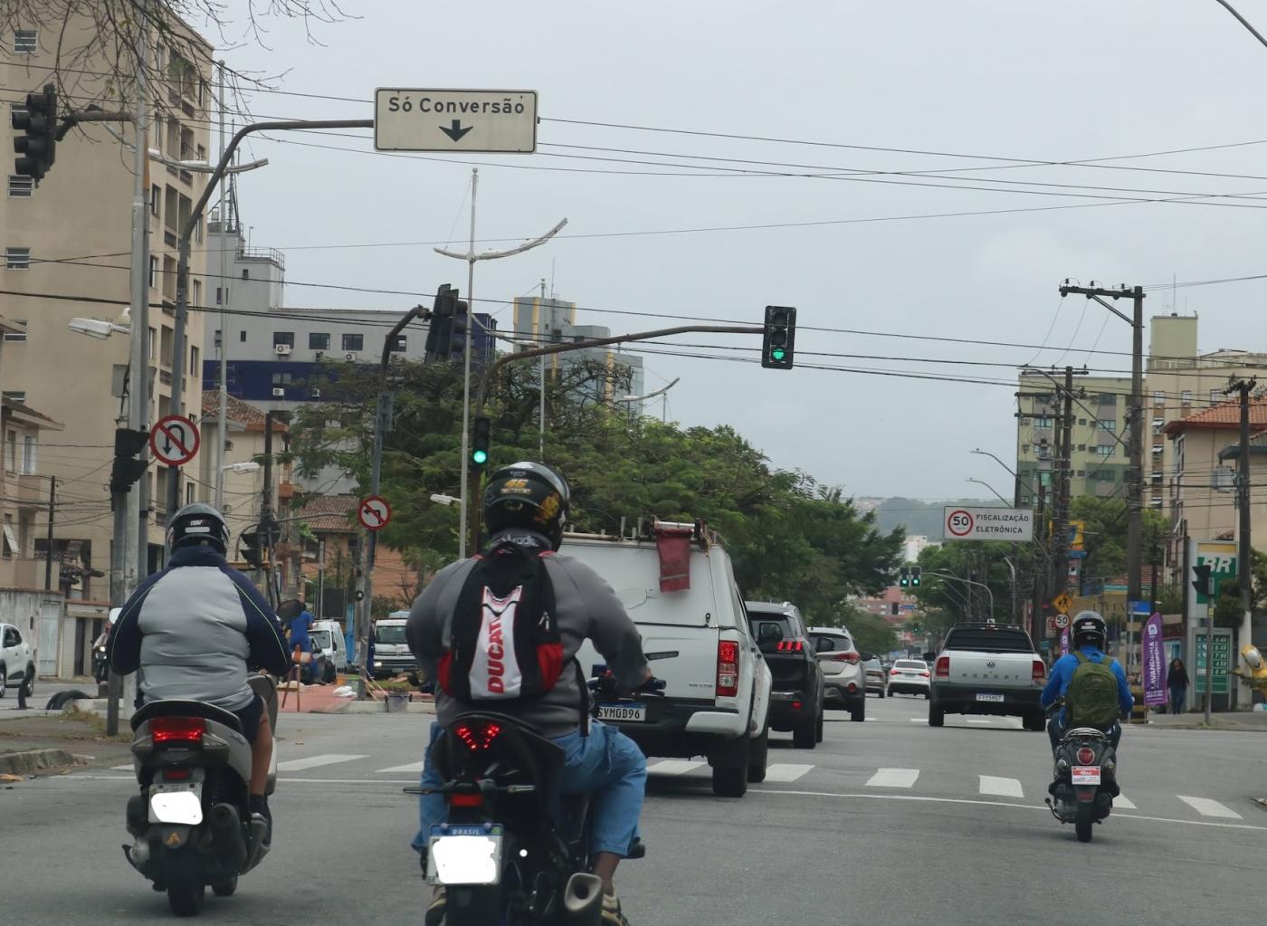 motos paradas em semáforo de avenida. #paratodosverem 
