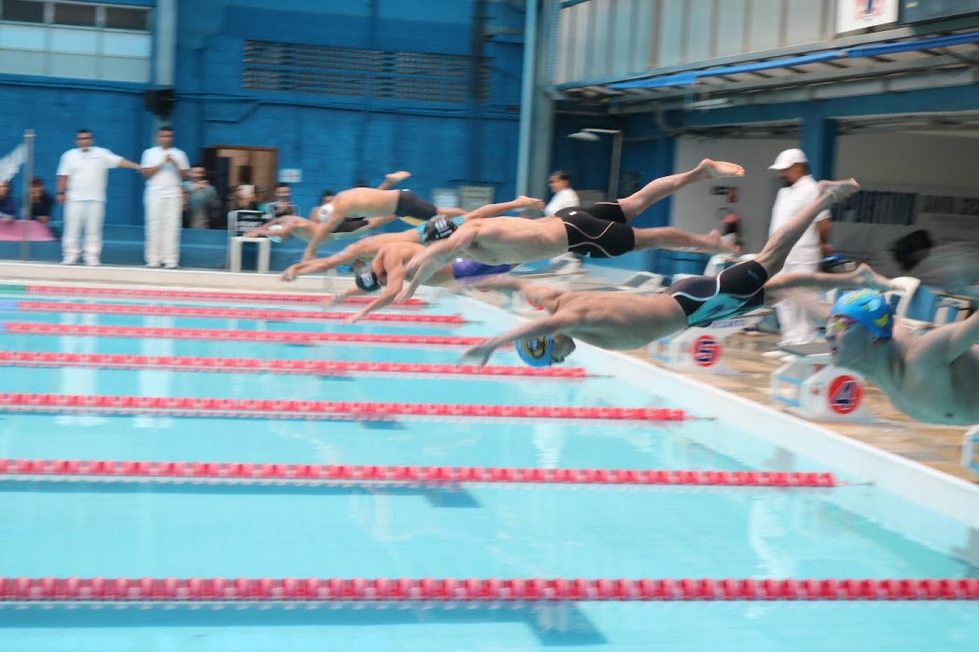 atletas pulam na piscina em prova #paratodosverem