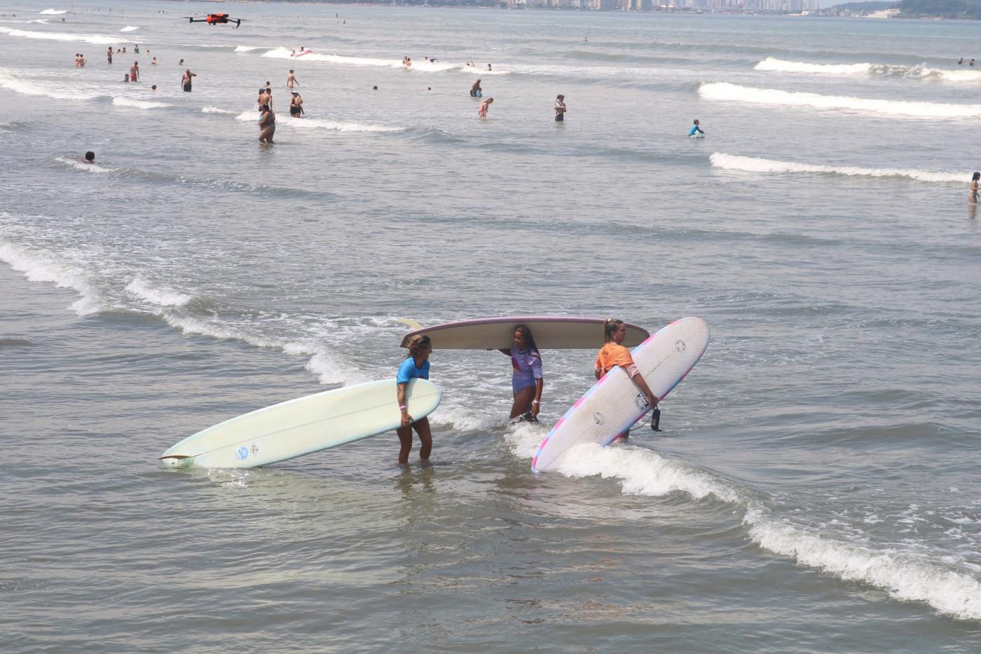 mulheres entram no mar com pranchões. #dparatodosverem