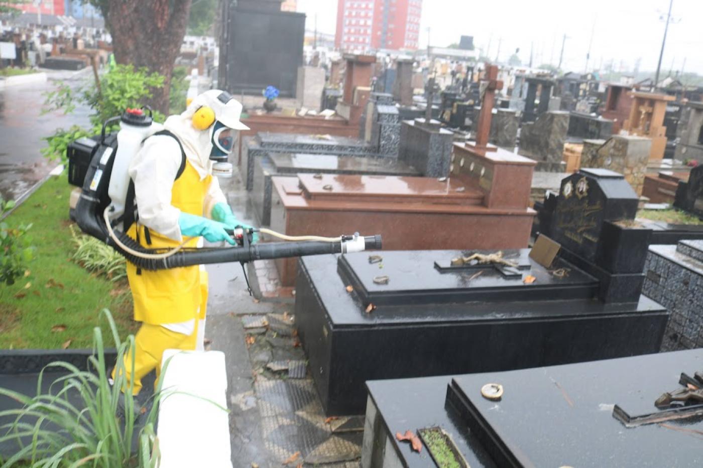 homem com roupa protetora nebuliza produto em cemitério. #paratodosverem 