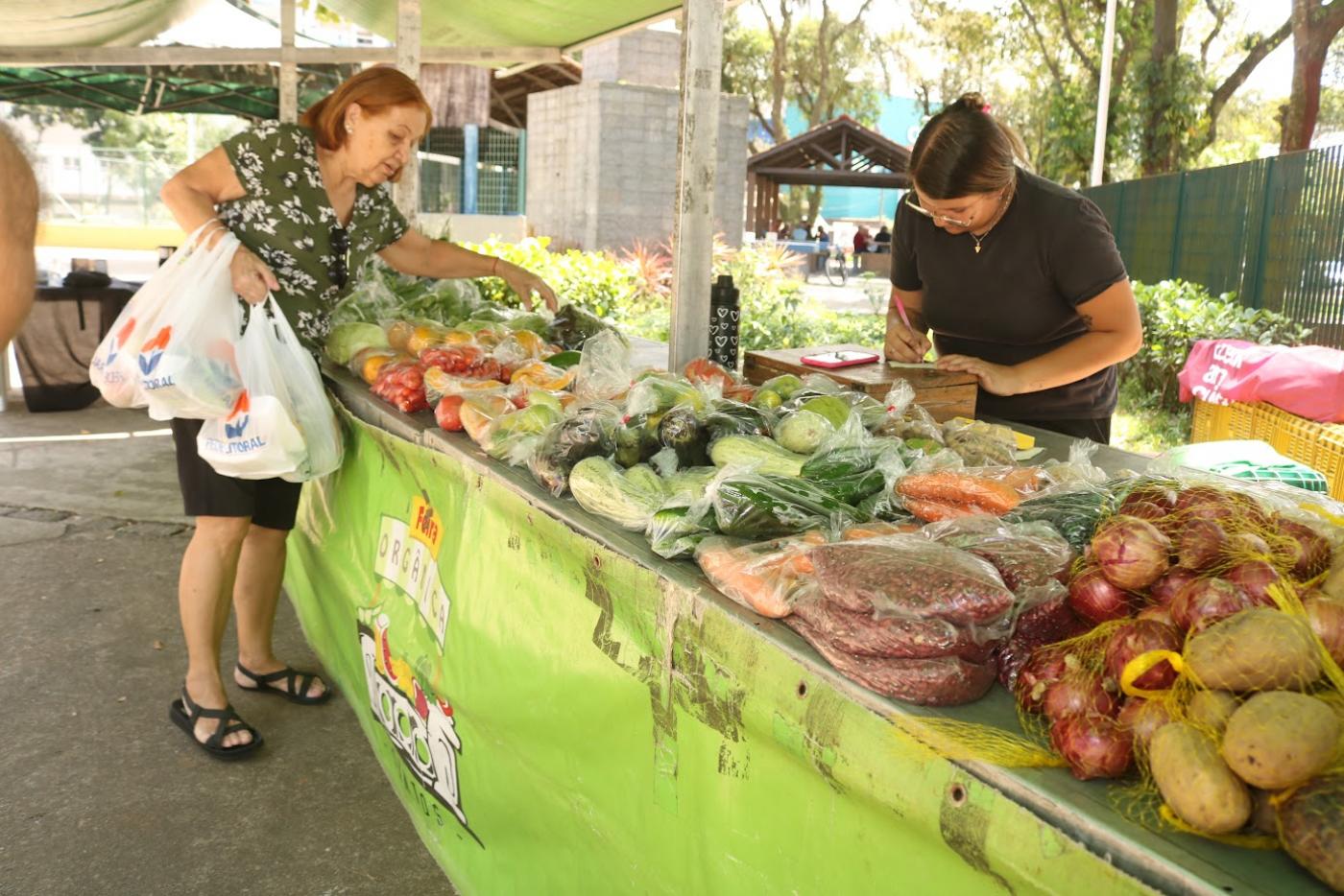 Mulher compra produtos na feira de orgânicos. #Paratodosverem