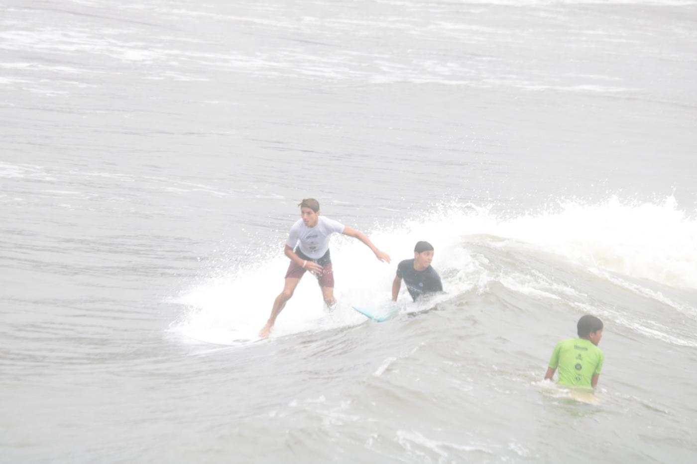 três jovens surfando. #paratodosverem