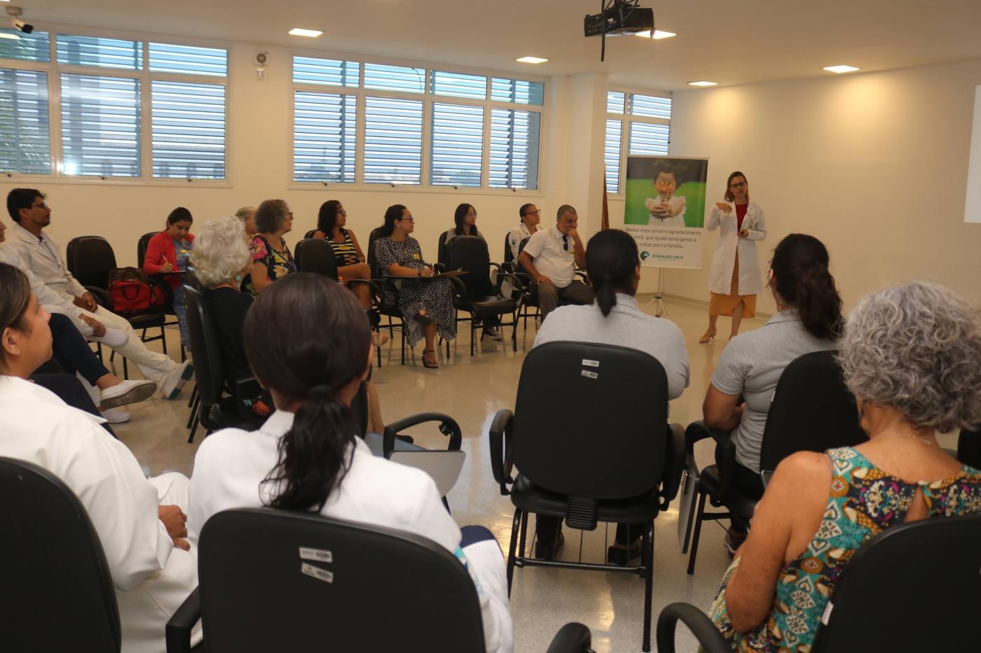 pessoas estão sentadas fazendo uma roda assistindo palestra. #paratodosverem