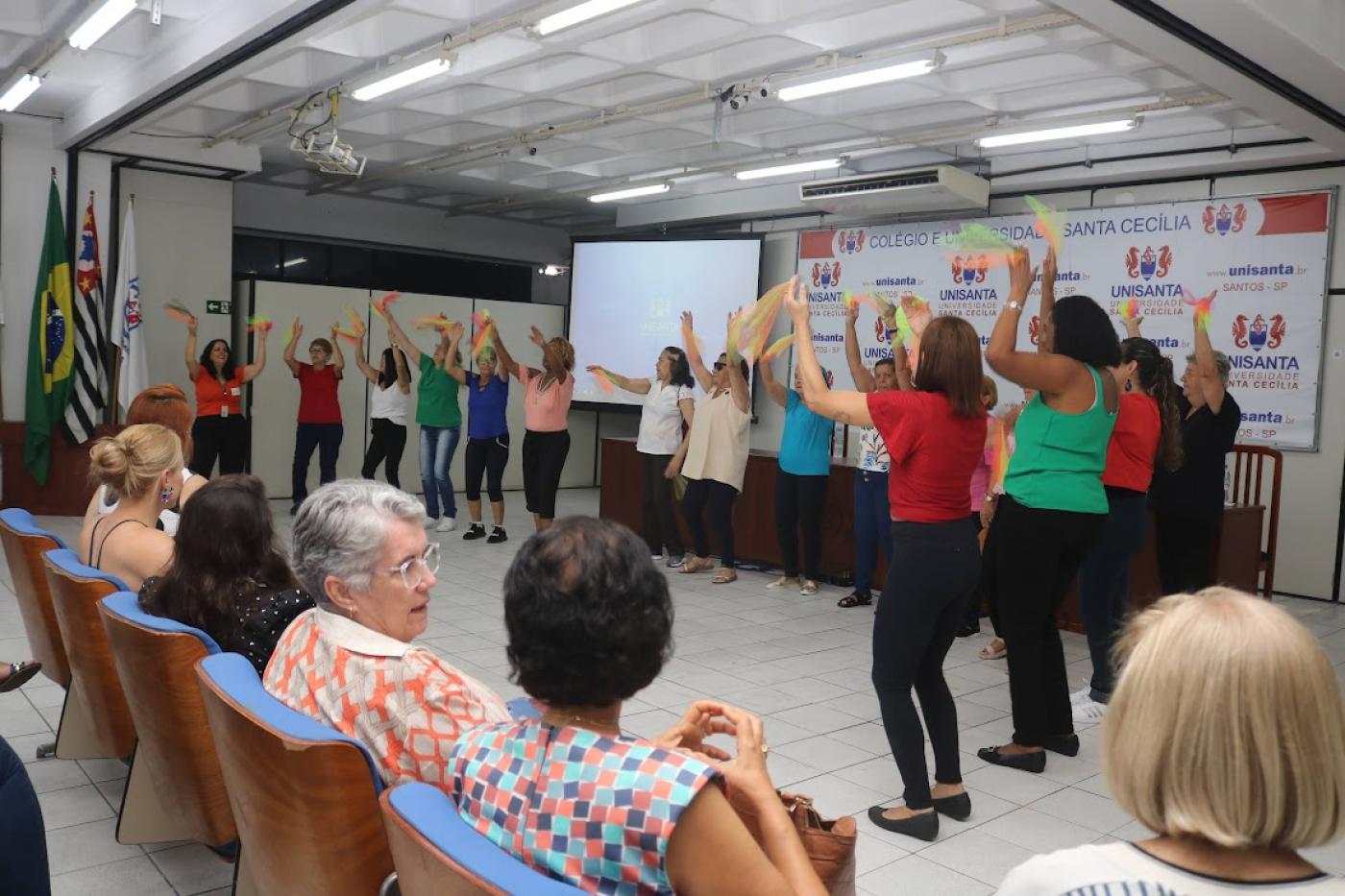 mulheres em pé balançando fitas #paratodosverem 