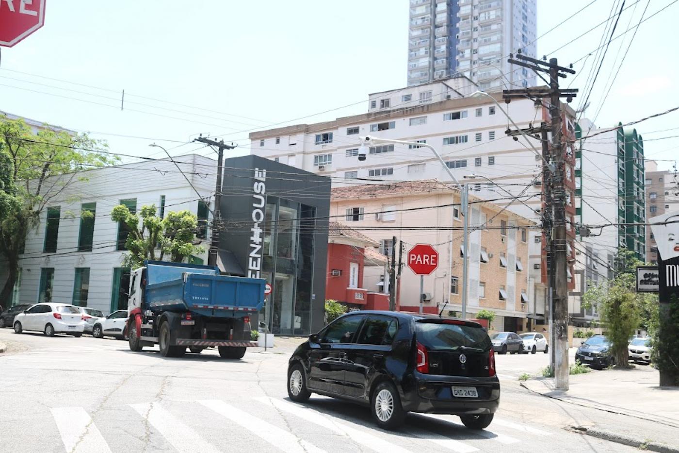 carro atrás de caminhão cruzando uma avenida. #paratodosverem