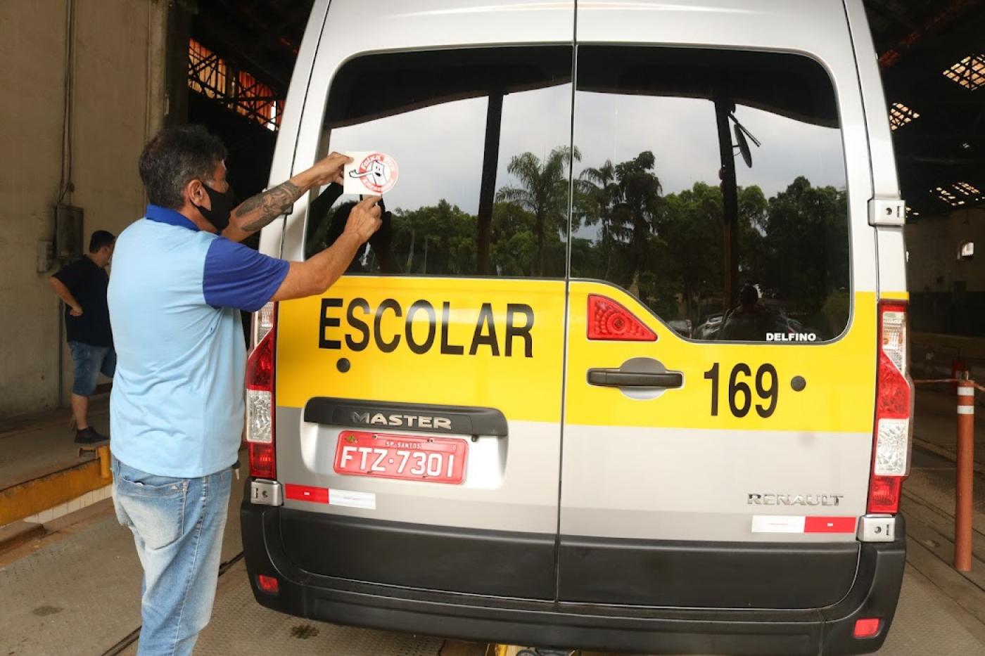 Homem cola adesivo na traseira da van escolar #paratodosverem