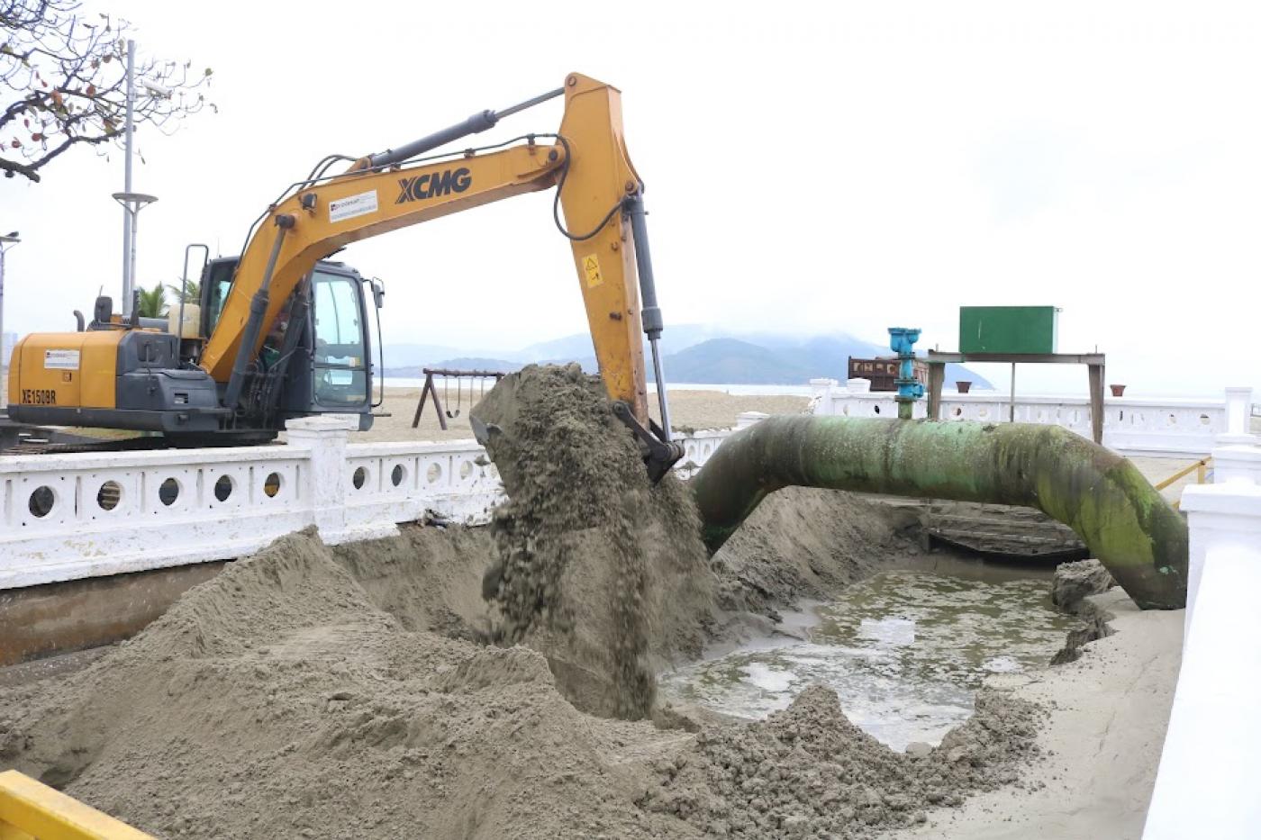 braço de escavadeira está lotado de areia removida de fundo de canal. #paratodosverem