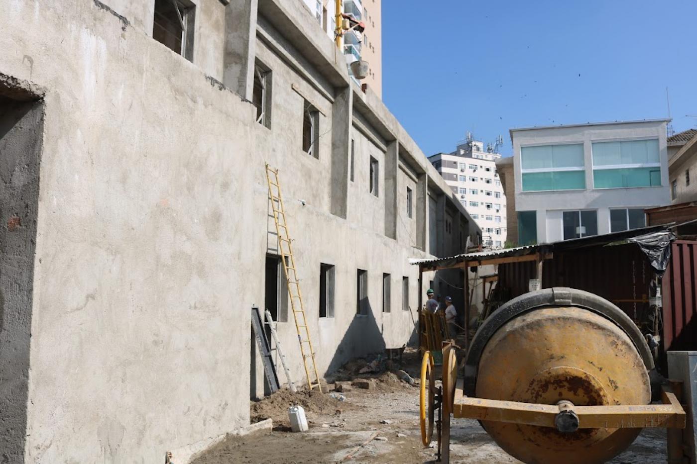 prédio em construção do lado esquerdo e betoneira à direita. #paratodosverem