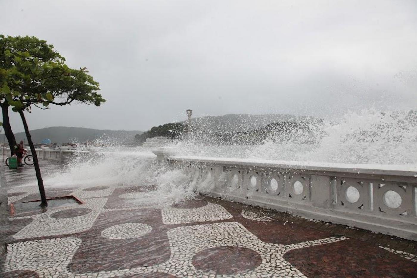 Ondas batendo em mureta da Ponta da Praia e água invadindo o calçadão. #paratodosverem