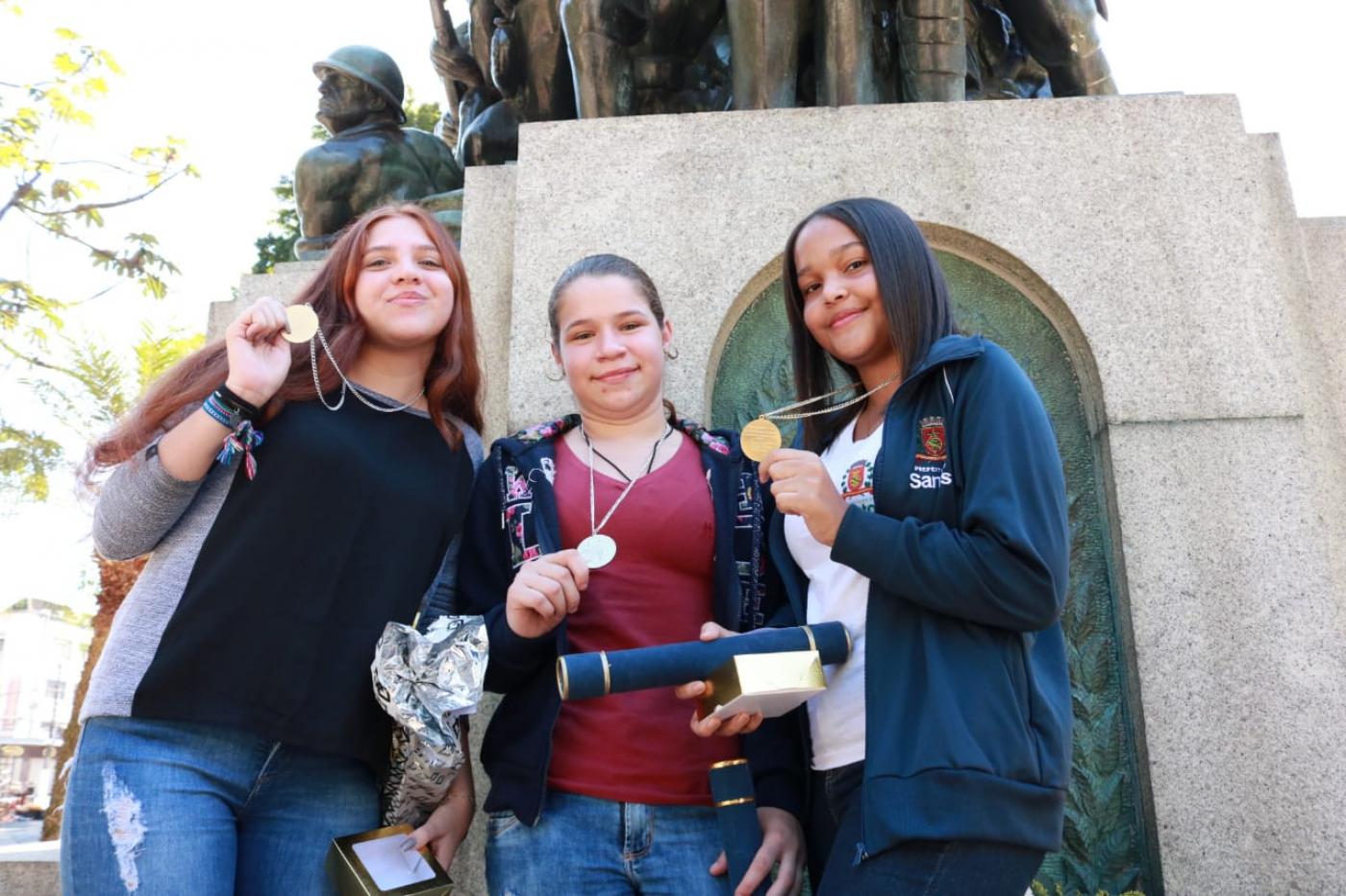 Luana, Ingrid e Ana Carolina exibem suas medalhas. #Pracegover