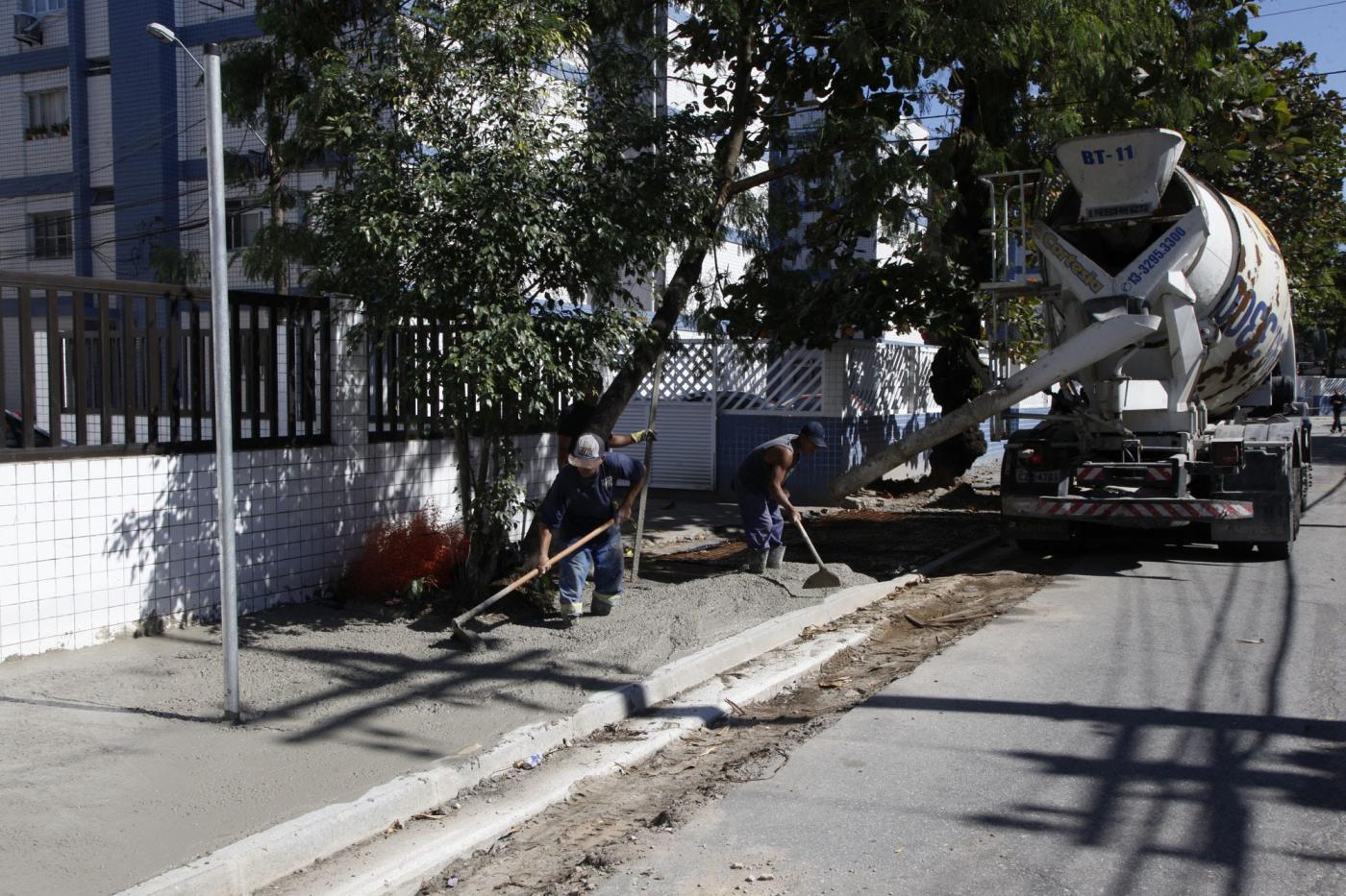 Homens trabalham em calçada #pracegover 