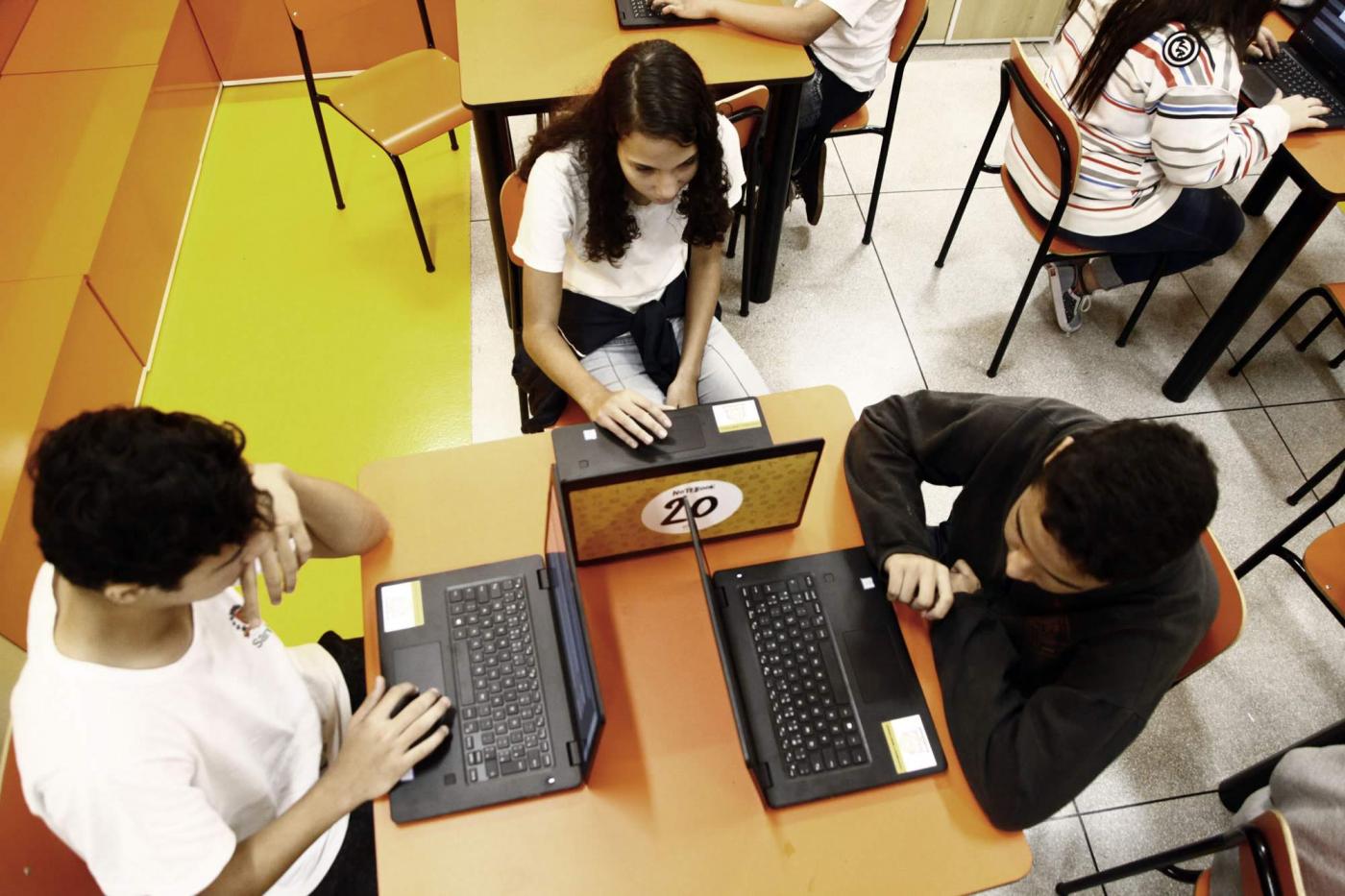 crianças votando em laptops #pracegover