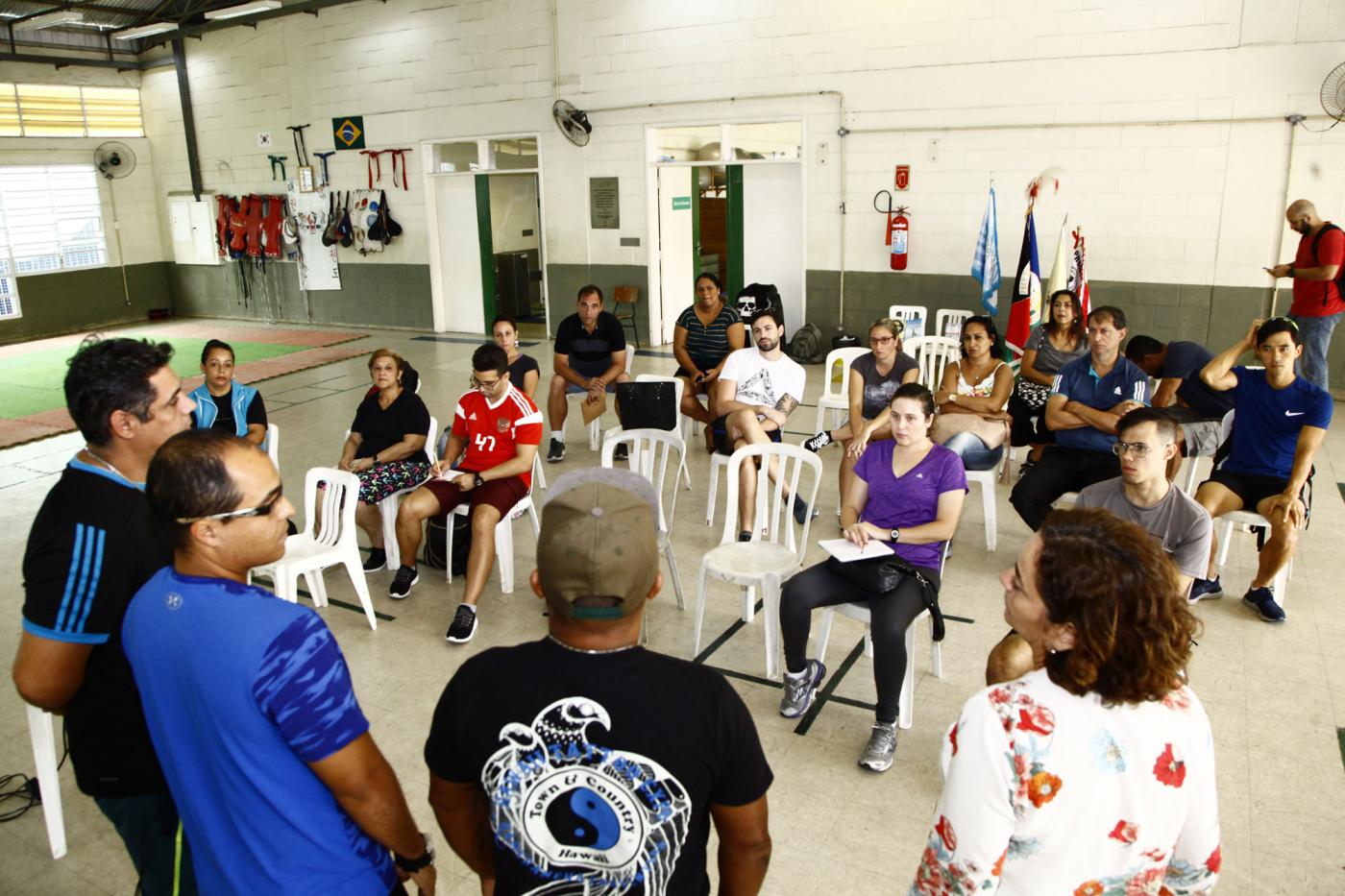 Professores sentados ouvindo quatro colegas na capacitação #pracegover 