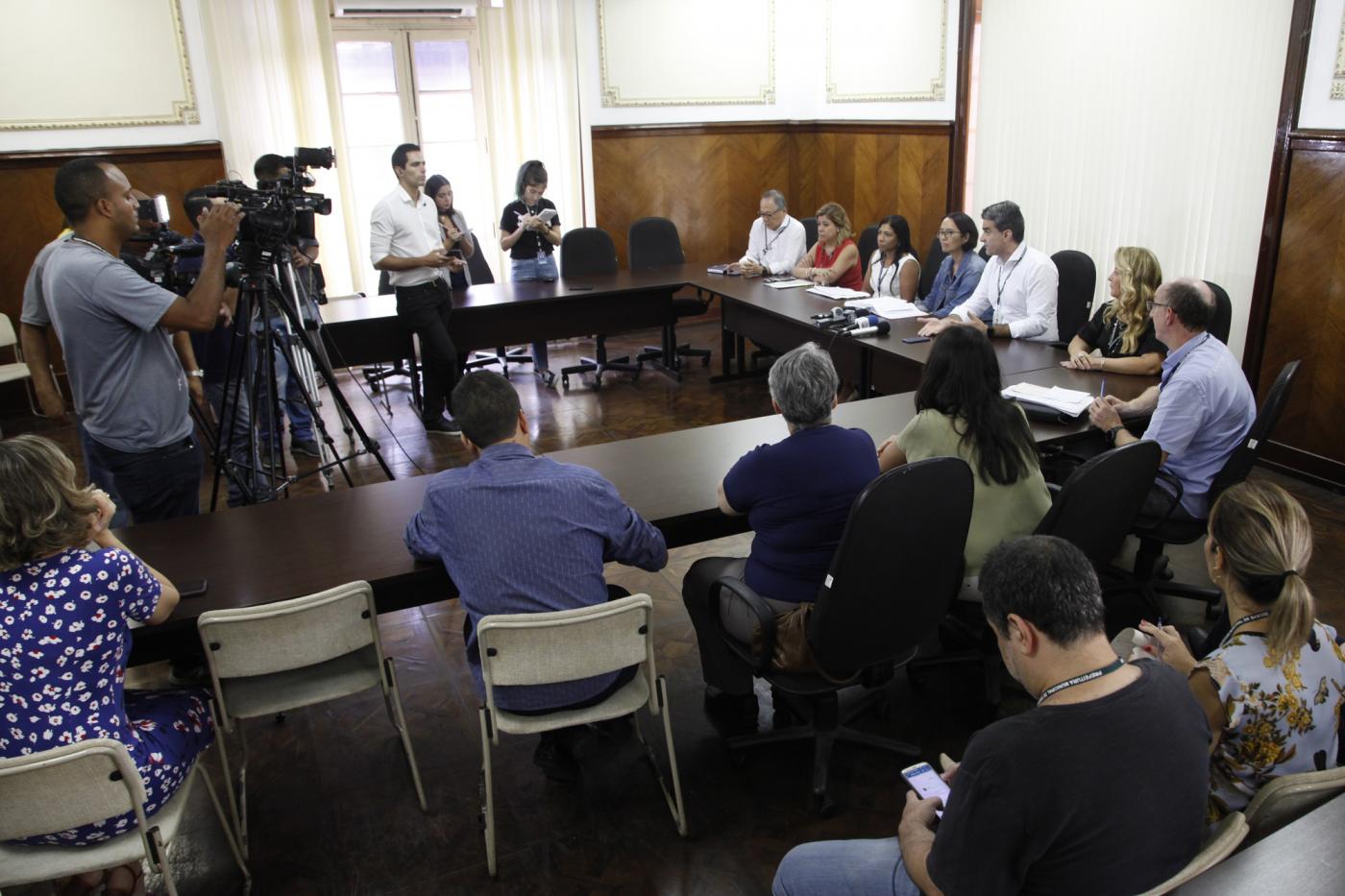 Reunião, com diversas pessoas sentada e cinegrafistas filmando. #paratodosverem