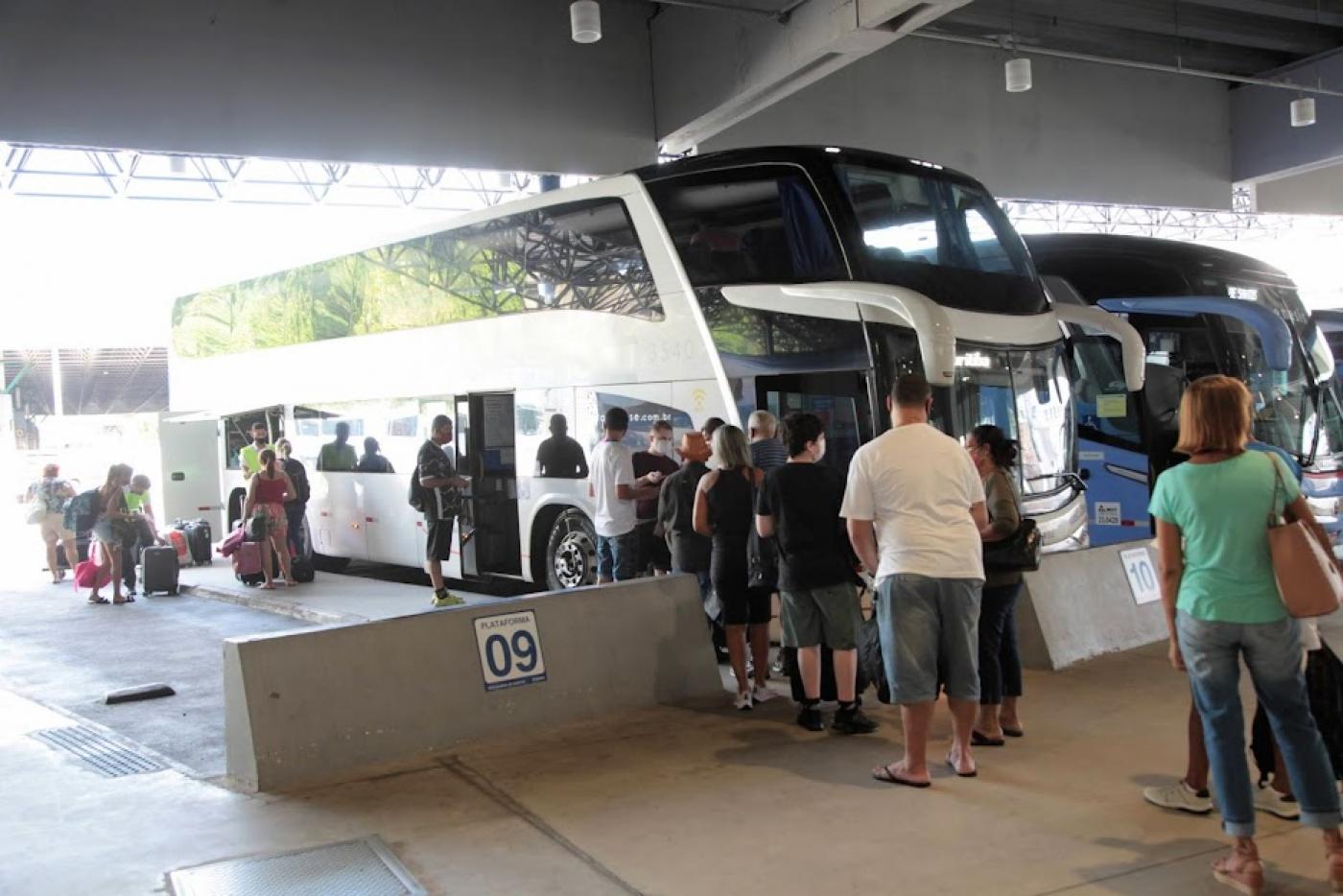 passageiros fazem fila para ingressa em ônibus parado em baia na rodoviária. #paratodosverem
