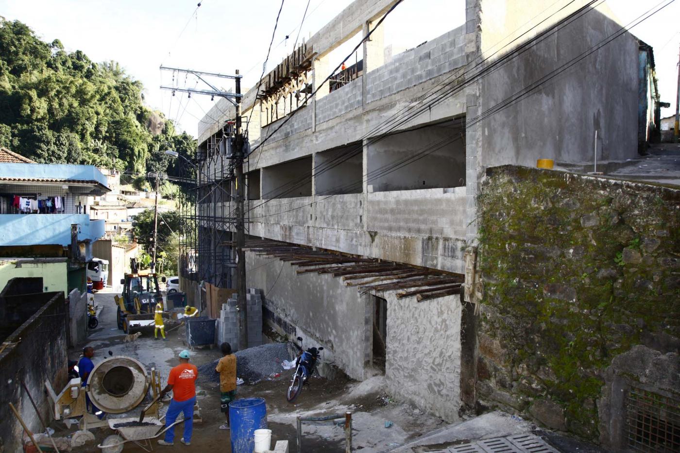 Vista lateral da construção de  nova escola, com três pavimentos em concreto em evidência. #Pracegover