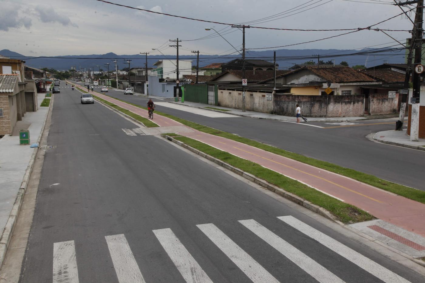 Trecho de avenida pavimentado, com faixa de pedestre e ciclovia no centro. #Pracegover