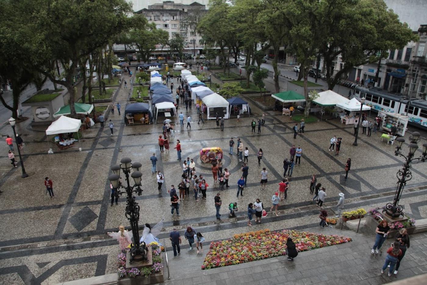 barracas montadas na praça mauá, movimento de pessoas e a escadaria da prefeitura repleta de vasos floridos. #paratodosverem