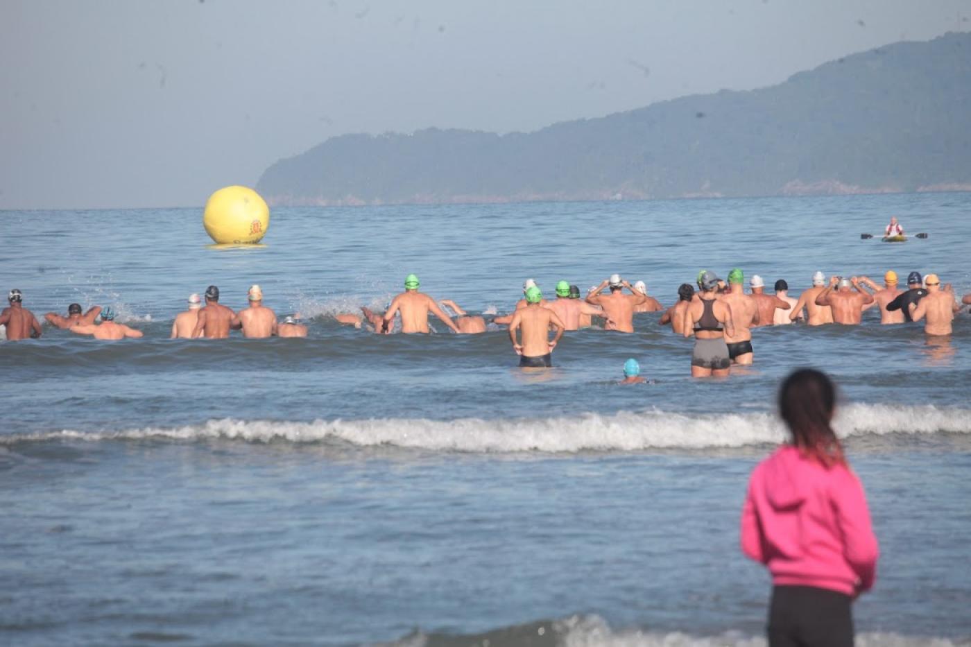 nadadores no mar e criança observa #paratodosverem