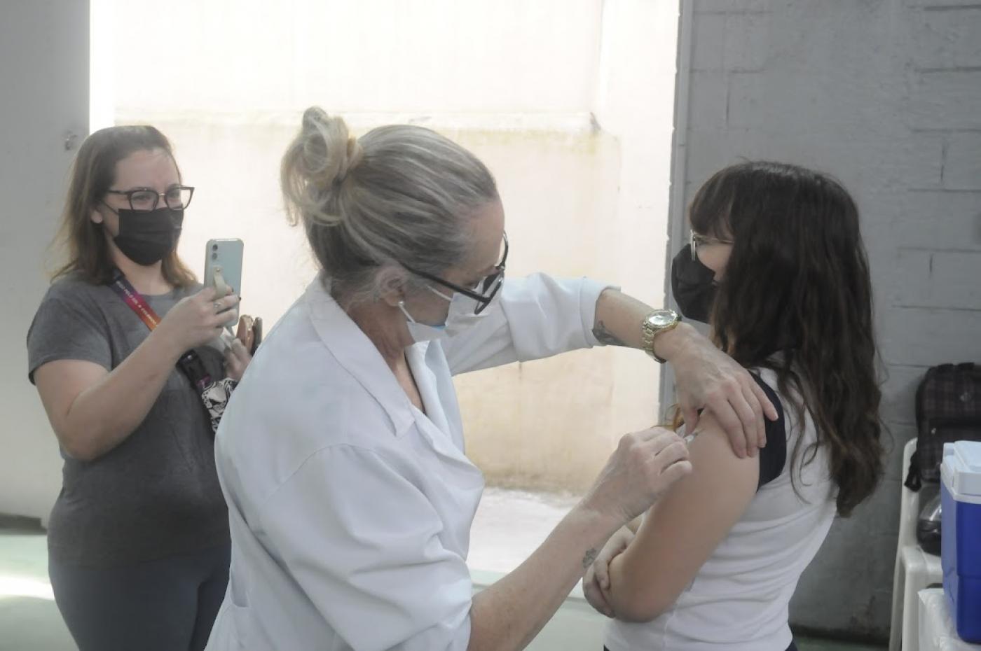 Mãe tira foto da filha sendo vacinada #paratodosverem