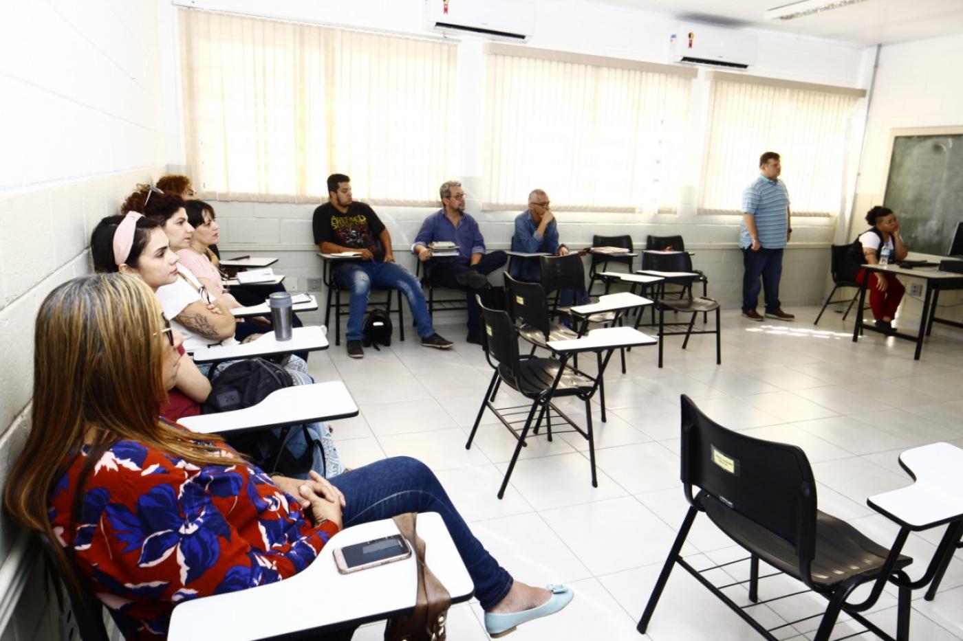 professores sentados na sala em capacitação #pracegover