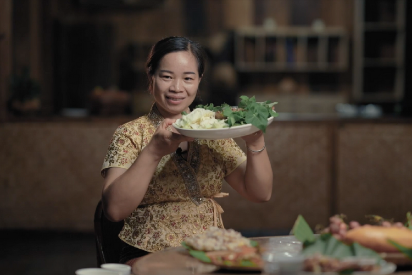 mulher chinesa segura prato cheio de comida e sorri para a foto. #paratodosverem 
