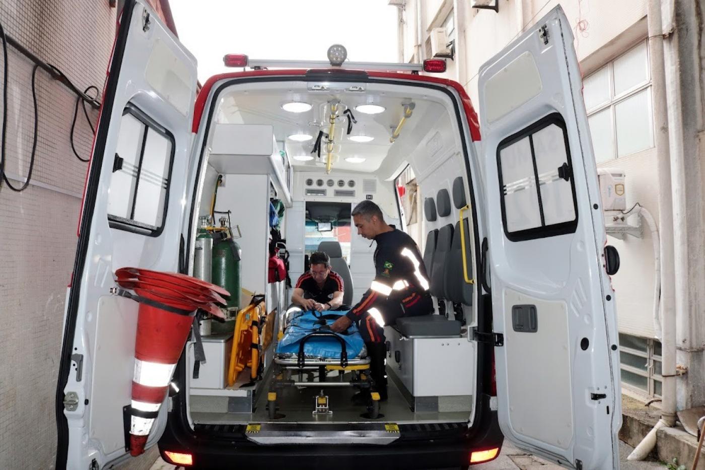 vista interna de ambulância com dois homens manusenado equipamentos. #paratodosverem 