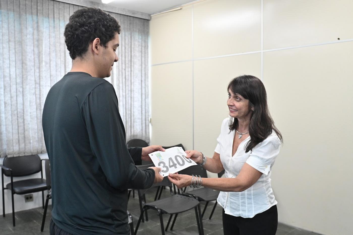 servidora entrega número a rapaz #paratodosverem 