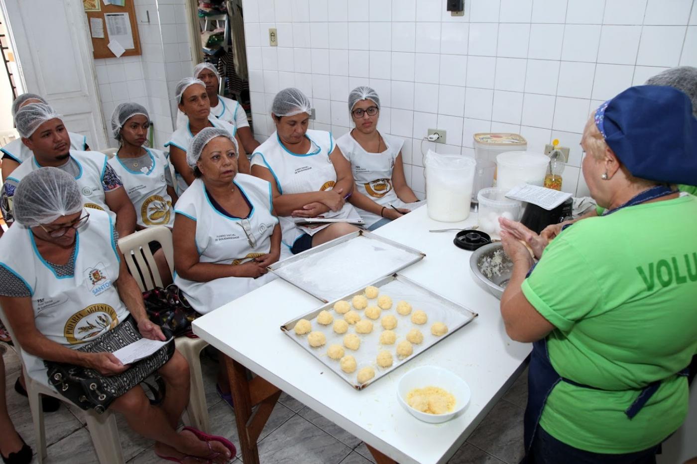 alunas assistem aula de panificação. pãezinhos crus estão sobre uma forma. #paratodosverem