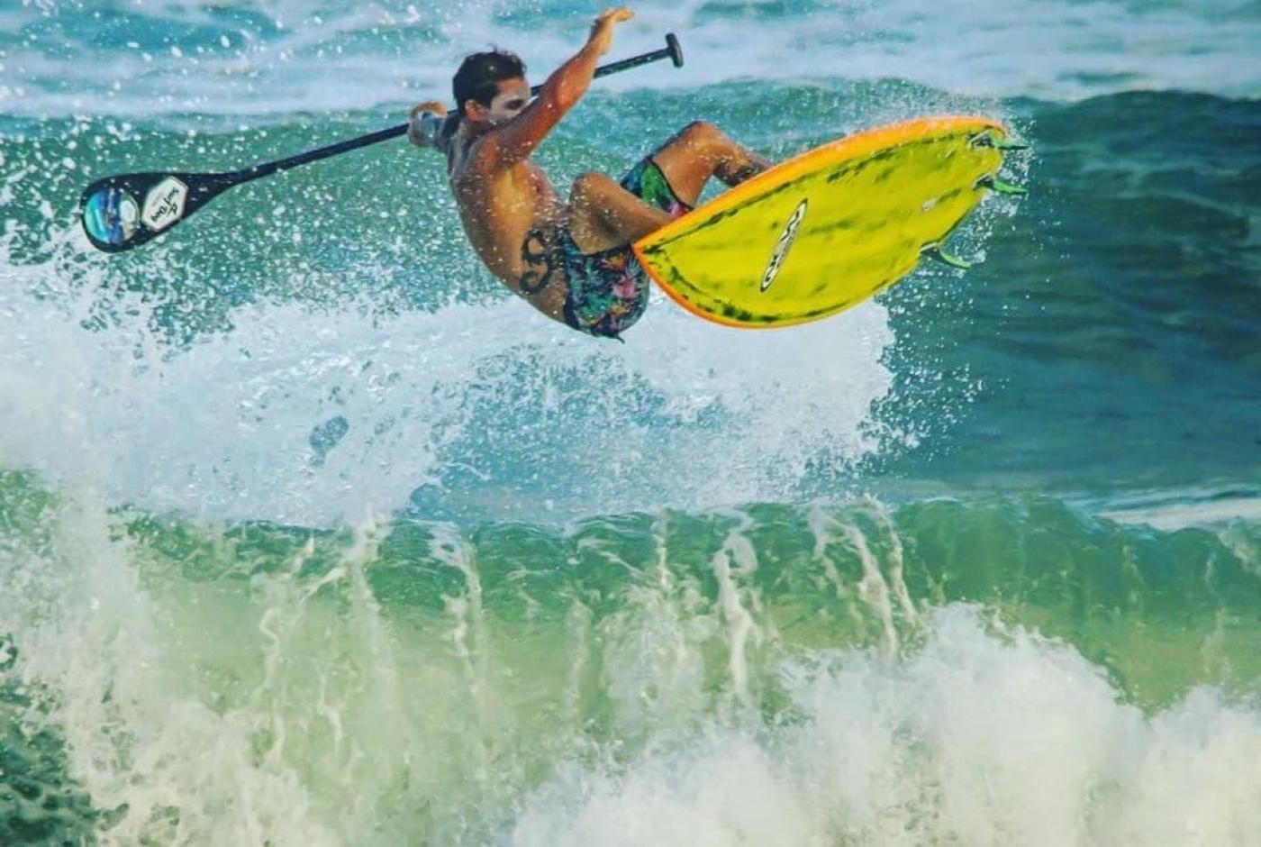 Atleta surfa em mar #paratodosverem