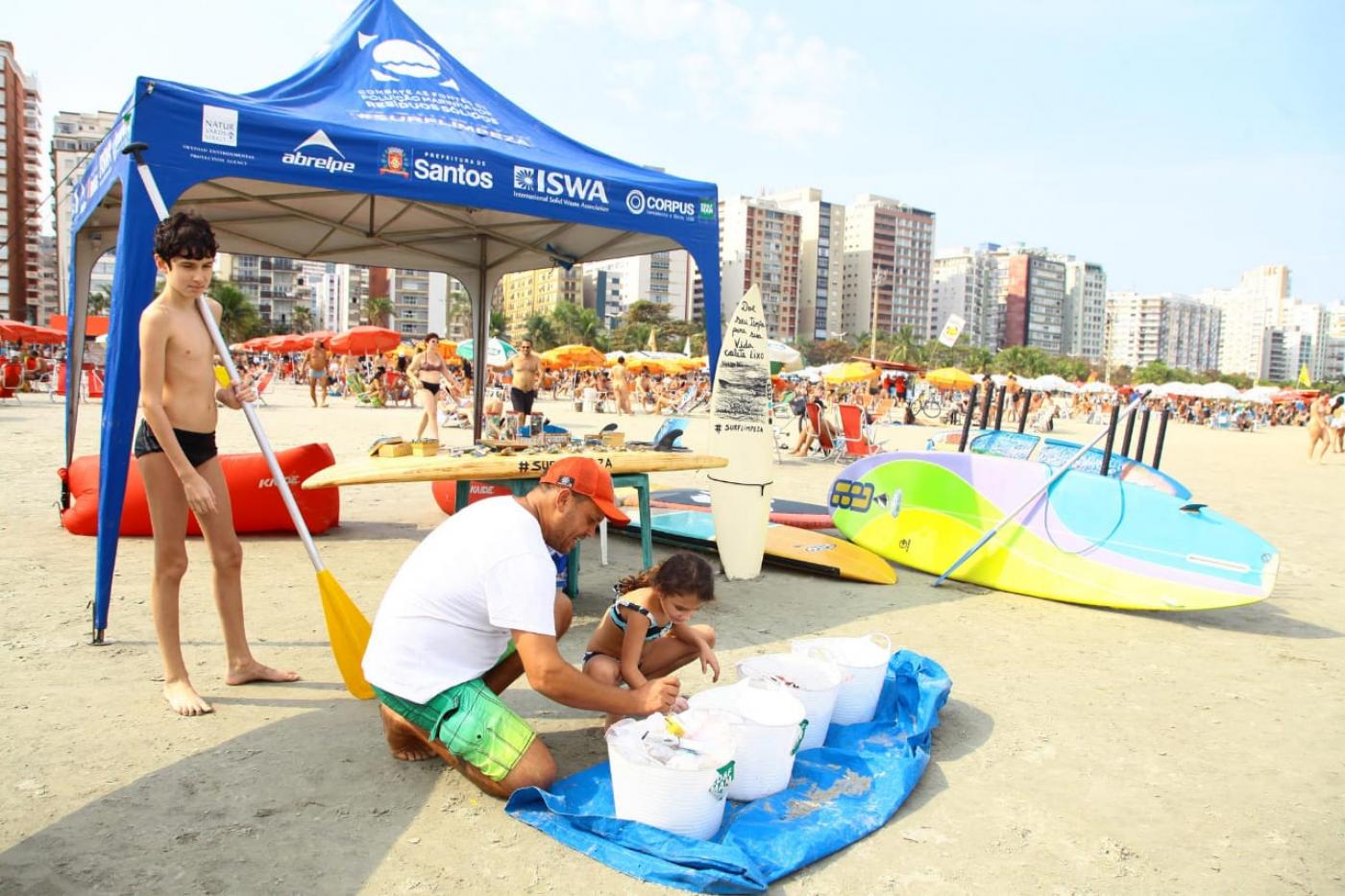 Menina entrega microlixo para aluguel de prancha de stand up. #pracegover