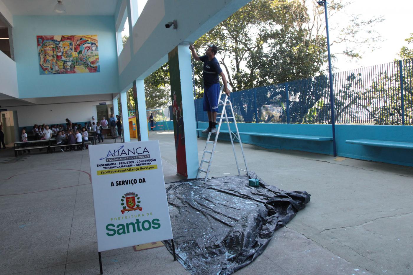 operário faz manutenção em parede de escola #pracegover