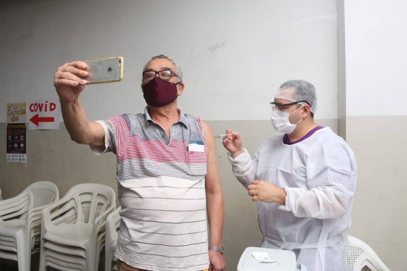 Homem faz selfie se vacinando #paratodosverem