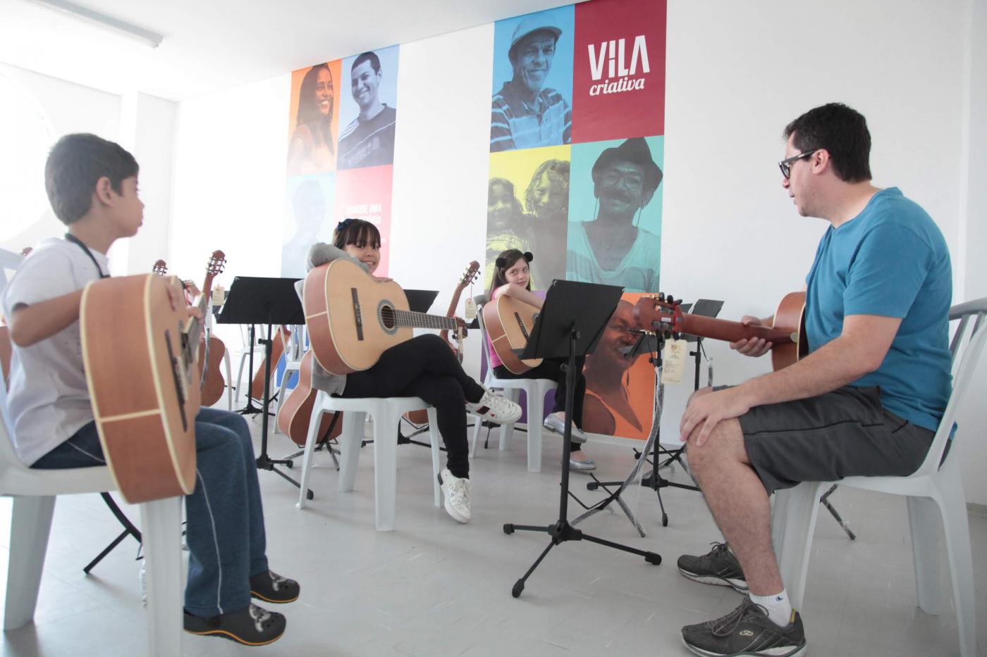 pessoas fazem aula de violão em vila criativa #pracegover 