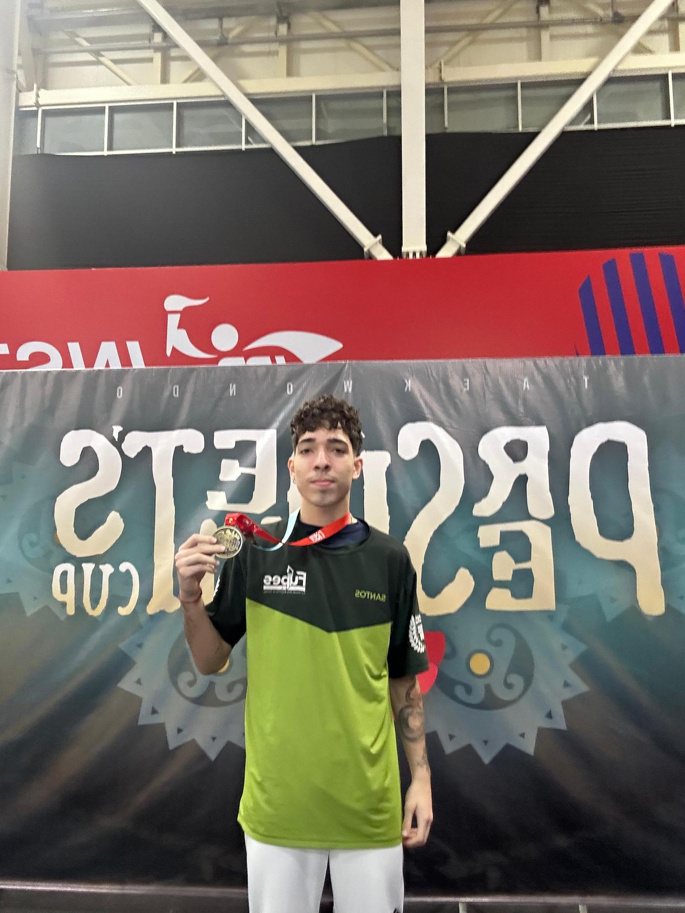 atleta com medalha na mão direita #paratodosverem