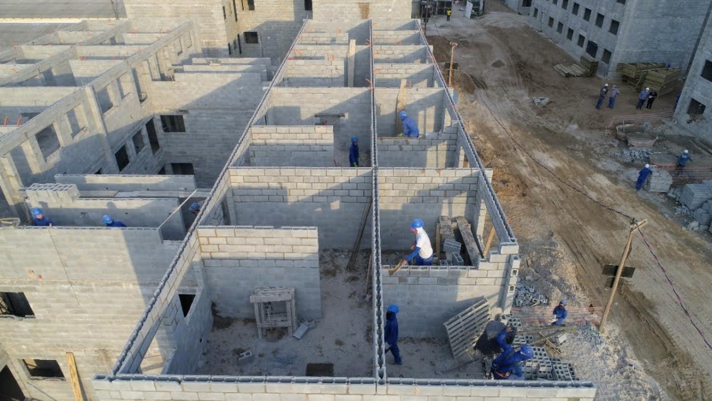 Vista geral de obra com homens trabalhando na alvenaria de futuras moradias. #Paratodosverem