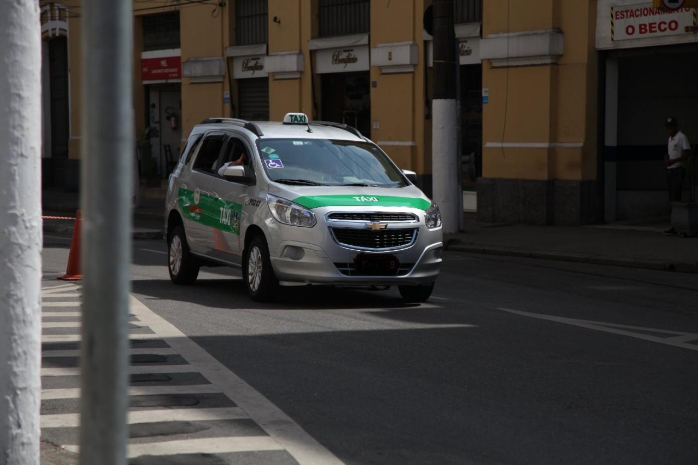 táxi circula em rua. #paratodosverem