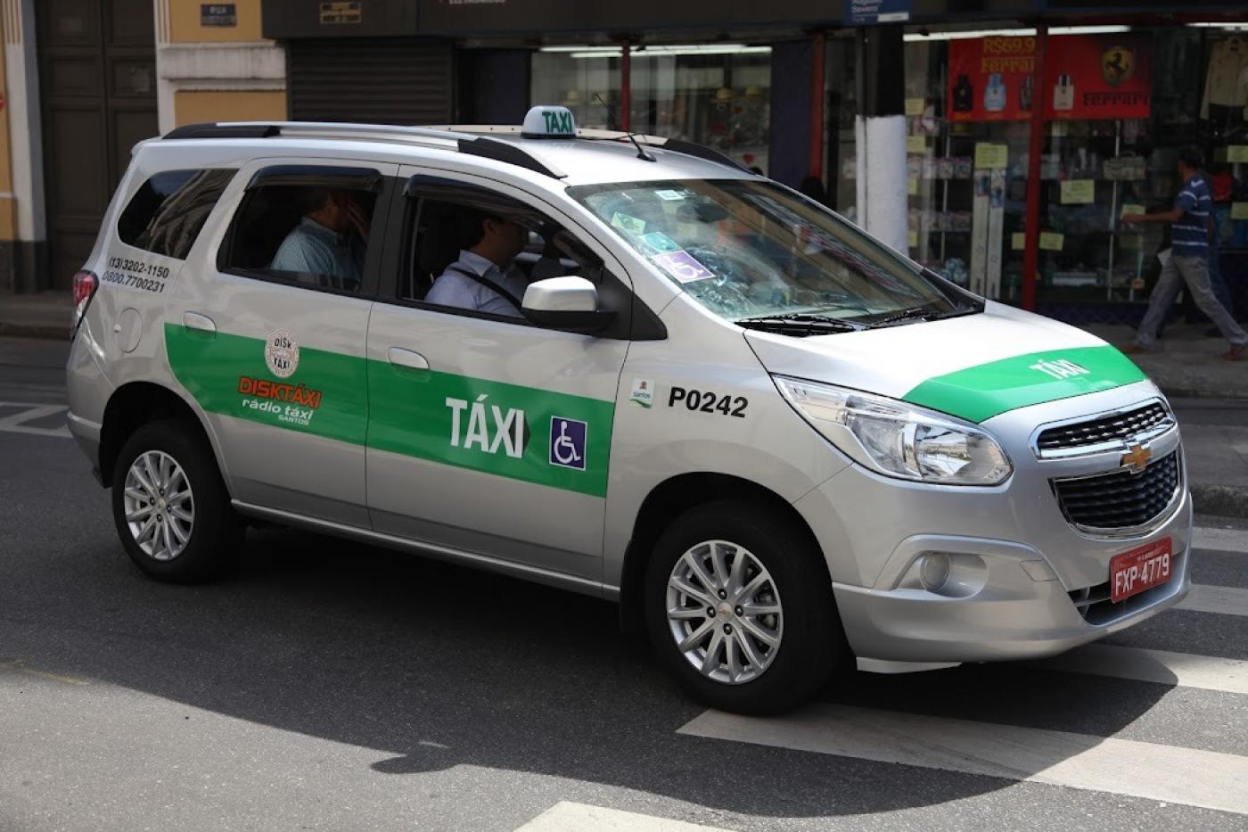 Táxi circulando em rua com passageiro. #paratodosverem