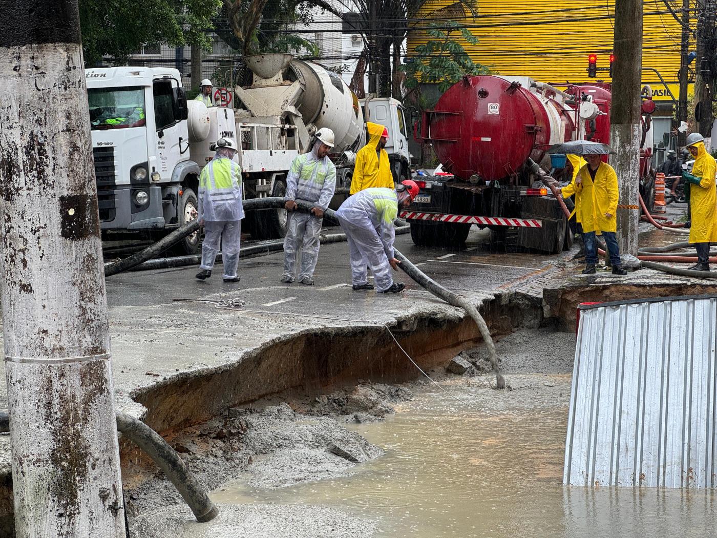 homens estão concretando área interna de obra. #paratodosverem 