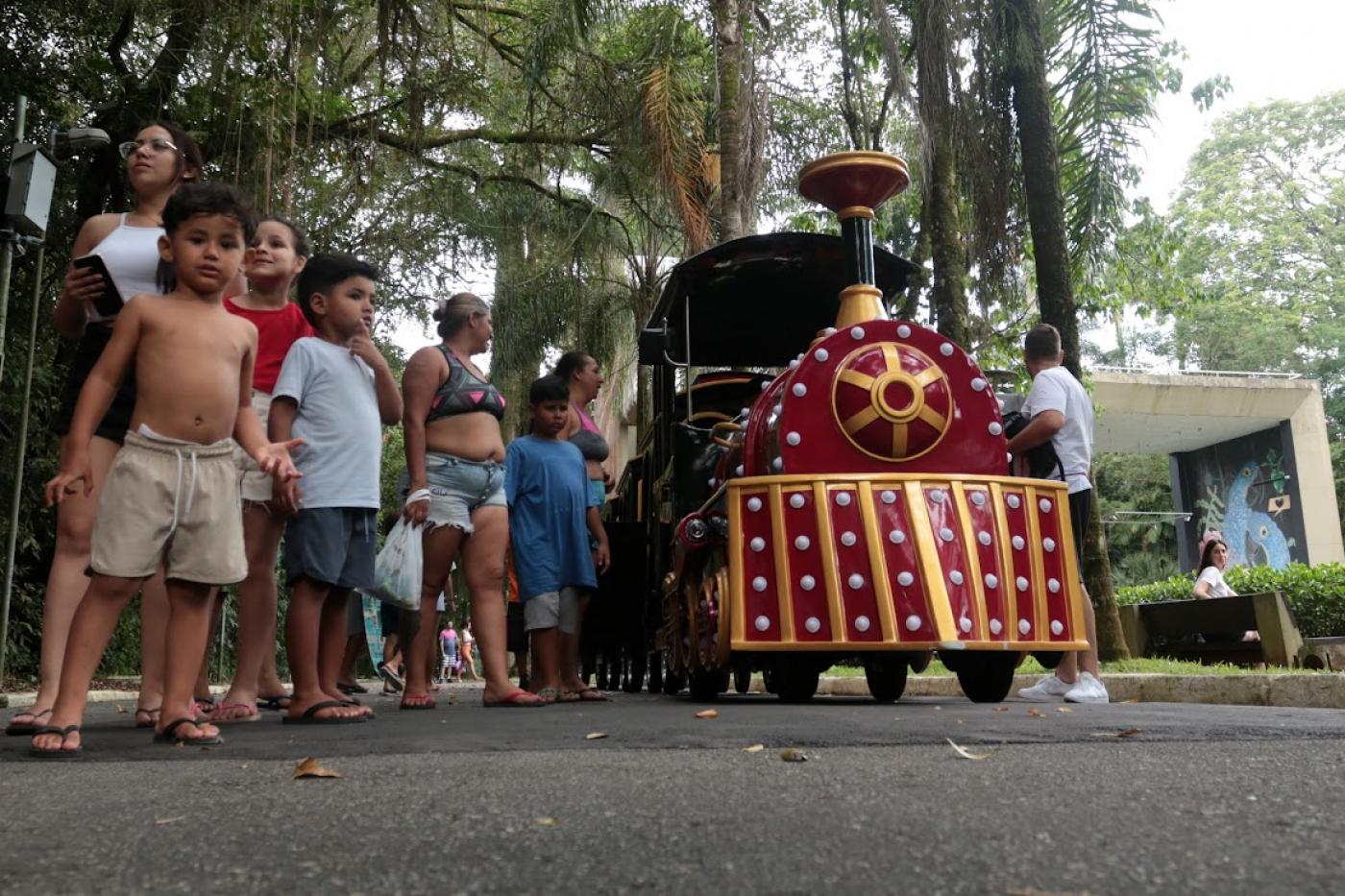 pessoas perto do trenzinho no jardim botânico #paratodosverem 