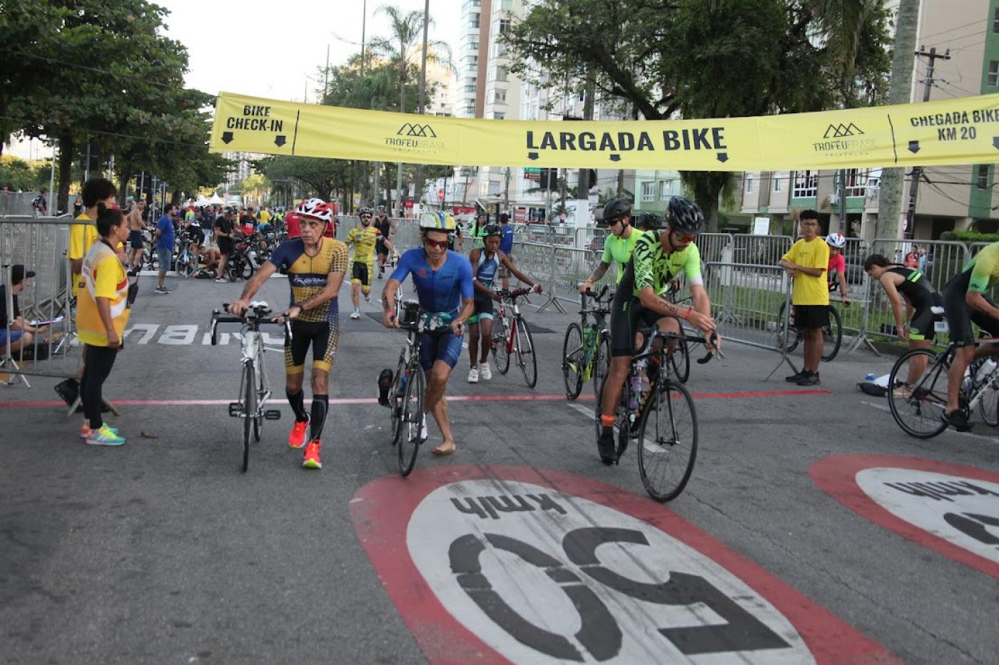 atletas pegando bicicleta durante a prova #paratodosverem 