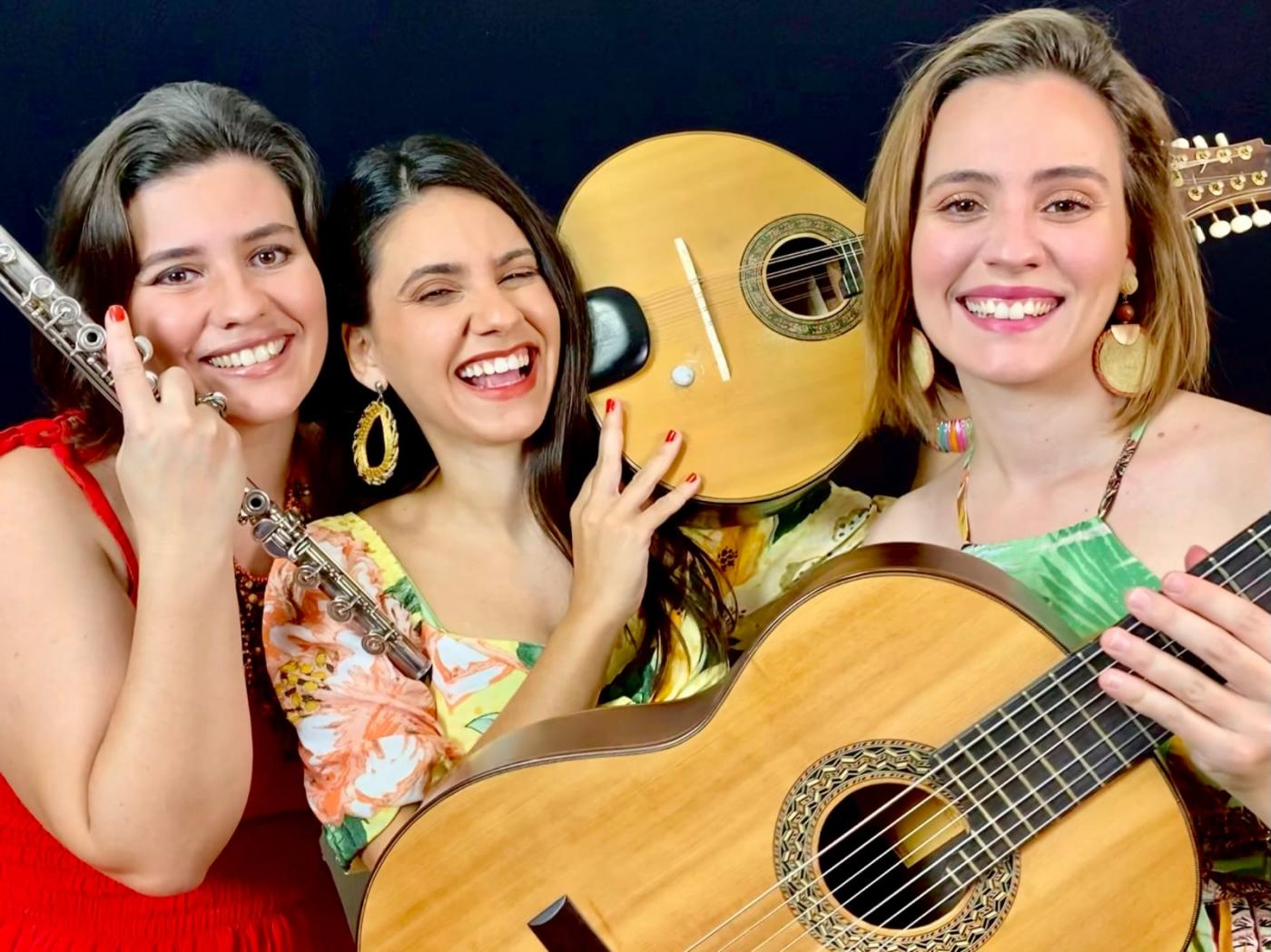 três mulheres seguram instrumentos musicais #paratodosverem
