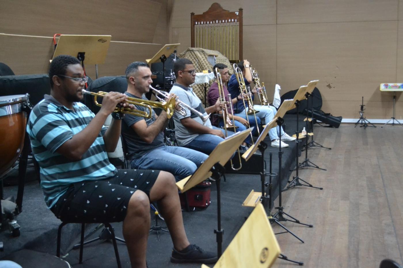 Wellinghton de Oliveira Santos está trocando trompete com outros músicos. #Paratodosverem