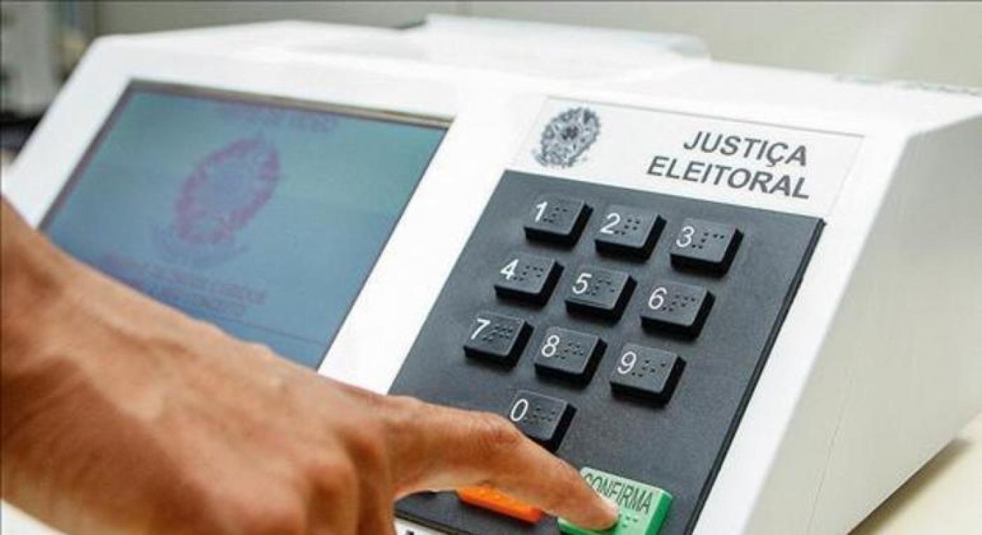 mão toca em tecla confirma da urna eletrônica. #paratodosverem