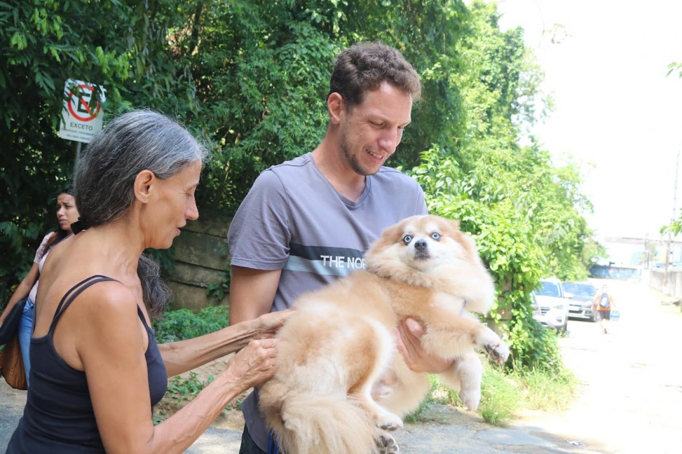 casal segura cão para vaciná-lo #paratodosverem 